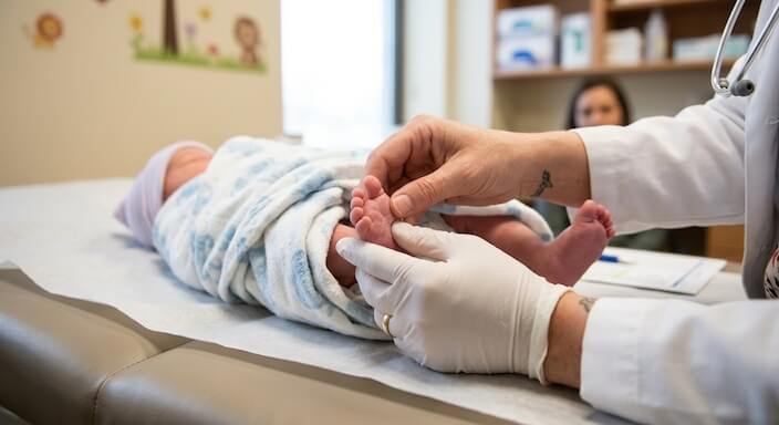 Pediatrician examining newborn
